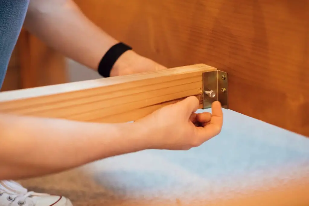 Tighten each screw to Stabilize a Wobbly Wooden Bed Frame